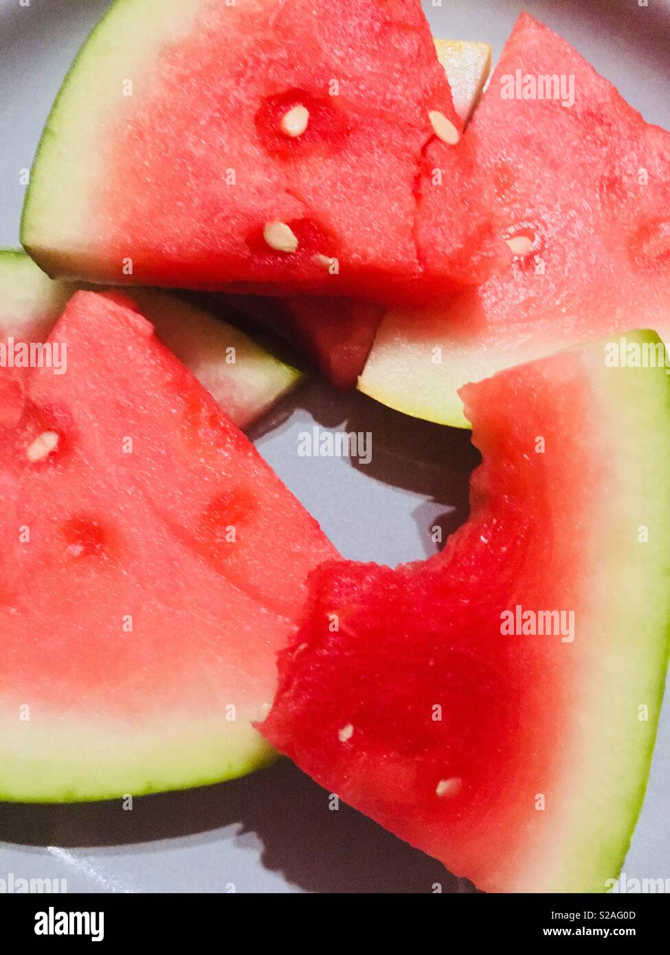 Bright, vibrant melon on a plate one piece has a bite taken out of it