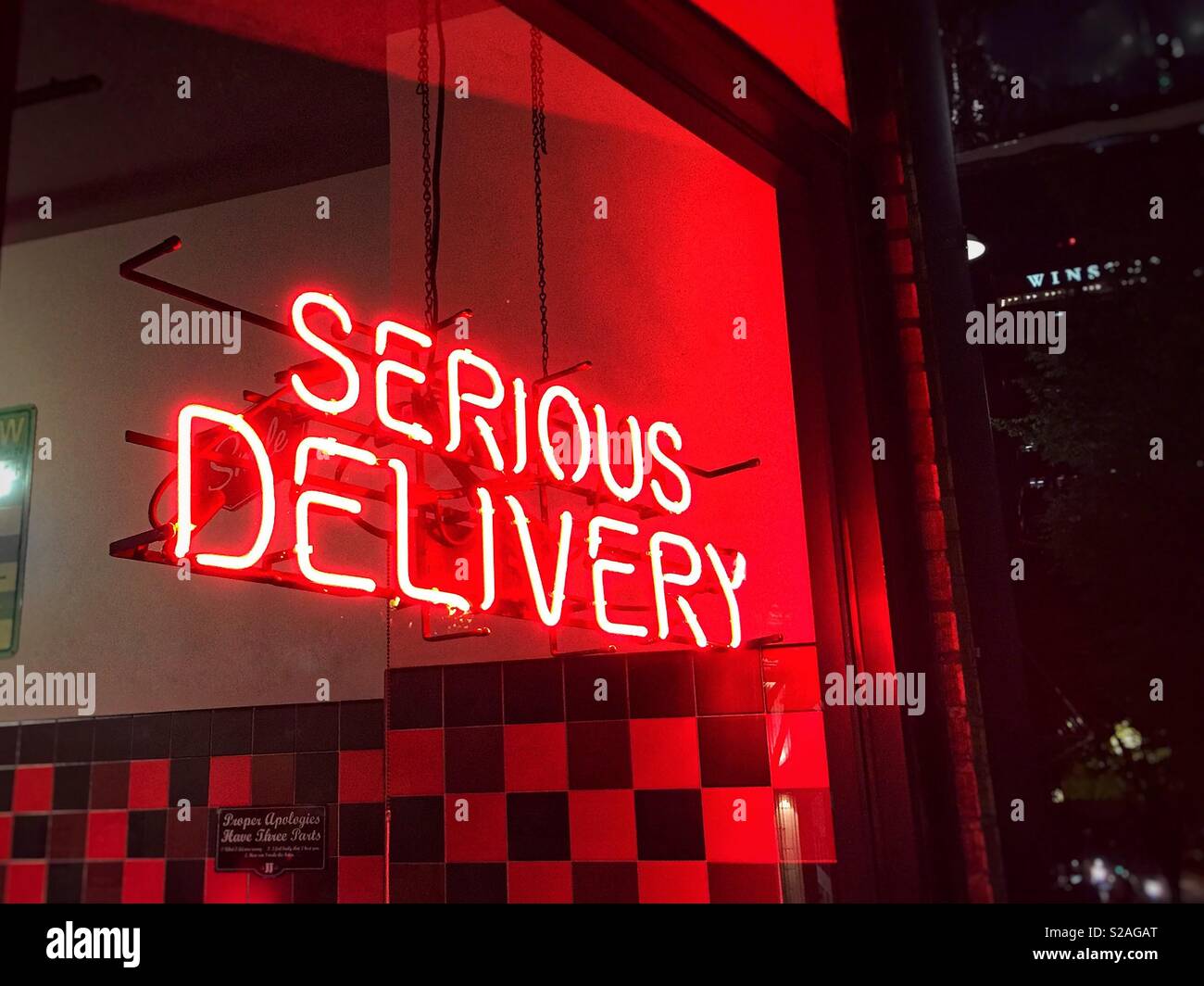 Serious delivery. Red neon sign in a fast food restaurant window. Stock Photo