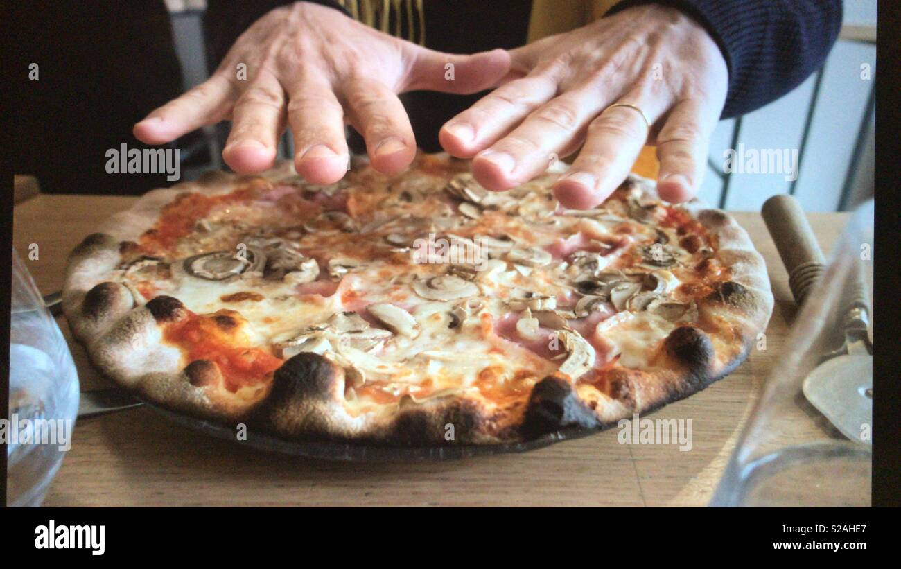 Warming up with a hot pizza on a cold day - Smartphone Captured Stock Image