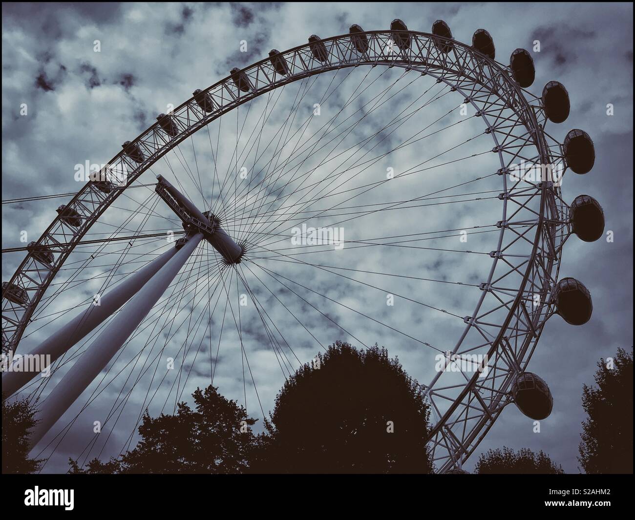 Looking up at the Coca-Cola London Eye, previously know as the British Airways Millennium Wheel. This 32 pod rotating Ferris Wheel is one of England’s most famous tourist attractions. © COLIN HOSKINS. Stock Photo