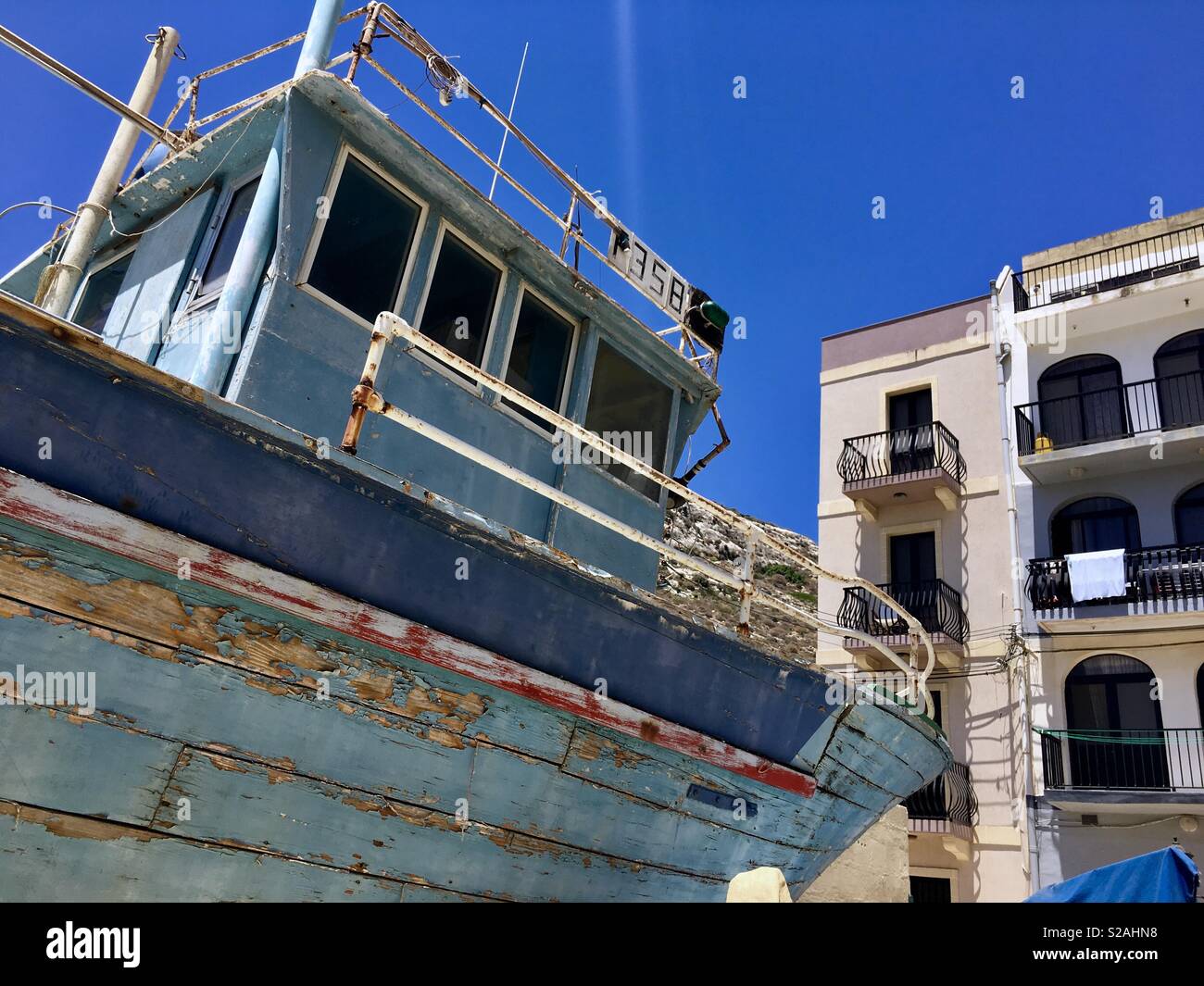 Traditional fisherman boat and local architecture in Gozo Malta Stock Photo