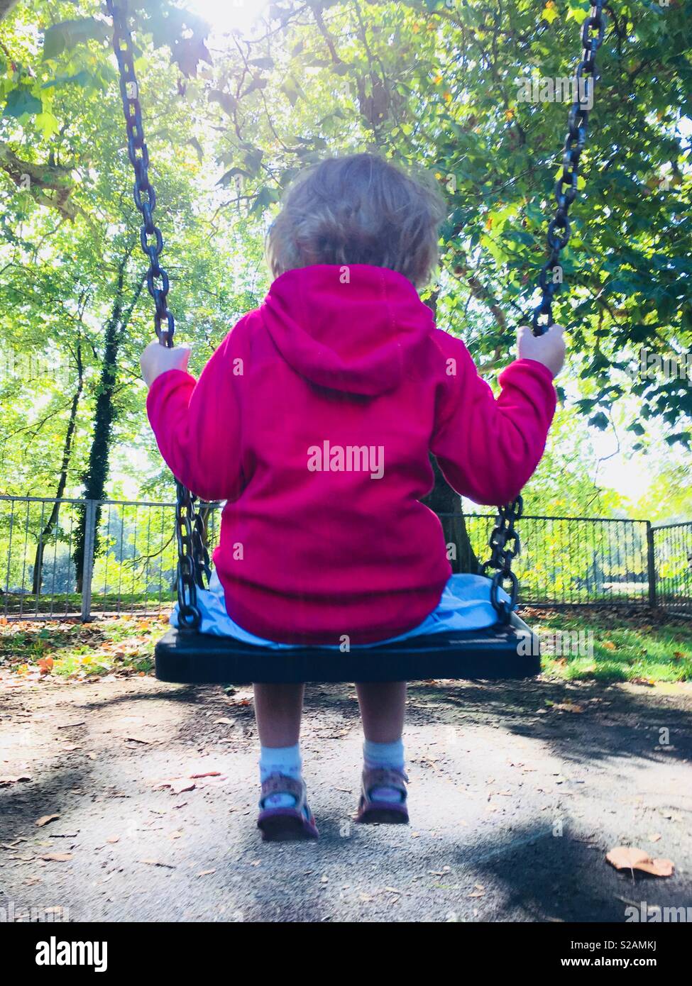 Four Year Old Girl Swinging On The Swing In The Swing Park - 