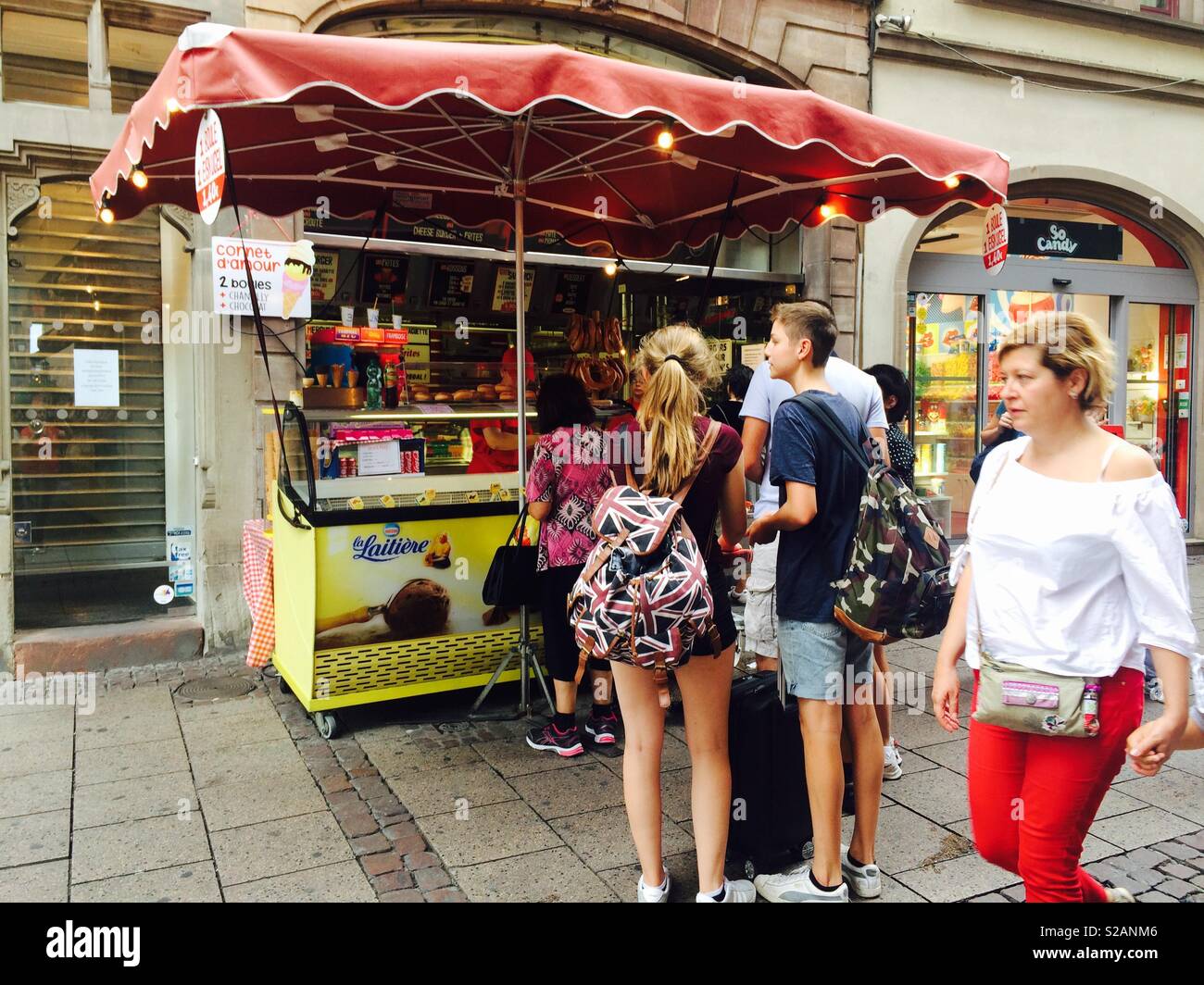 Ice cream and refreshments stand in the streets of Strasbourg in France with a queue of people waiting to be served Stock Photo