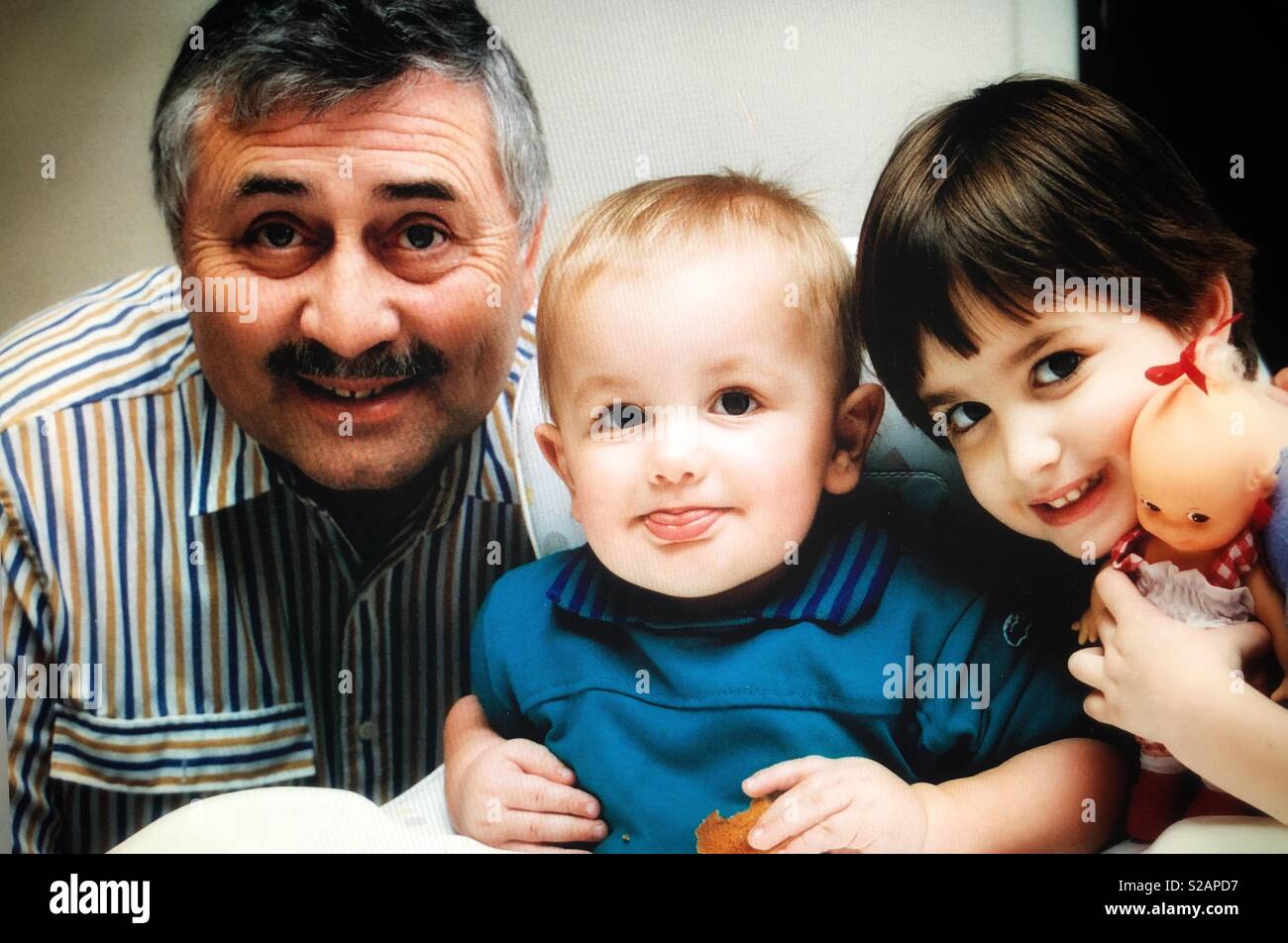 A grandfather poses with his grandson and granddaughter Stock Photo