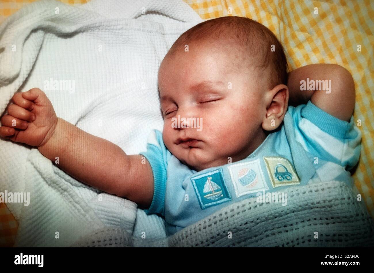 A baby boy sleeping with his arm extended Stock Photo