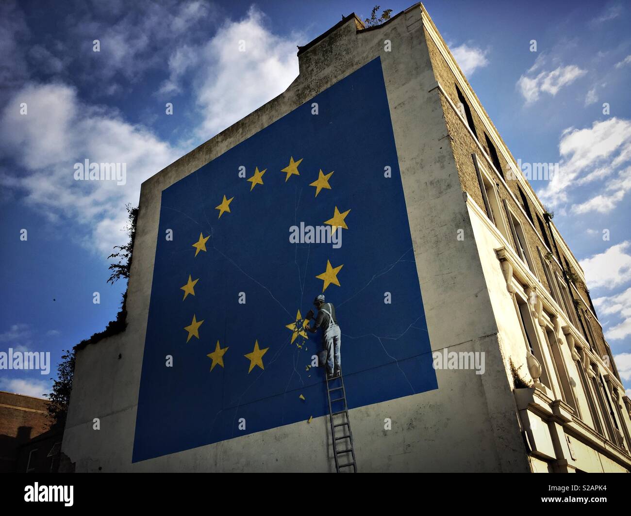 A mural by graffiti artist “Banksy” depicting a worker chiselling away a star representing the U.K on an EU flag following Brexit is seen in Dover in southeast England. Stock Photo