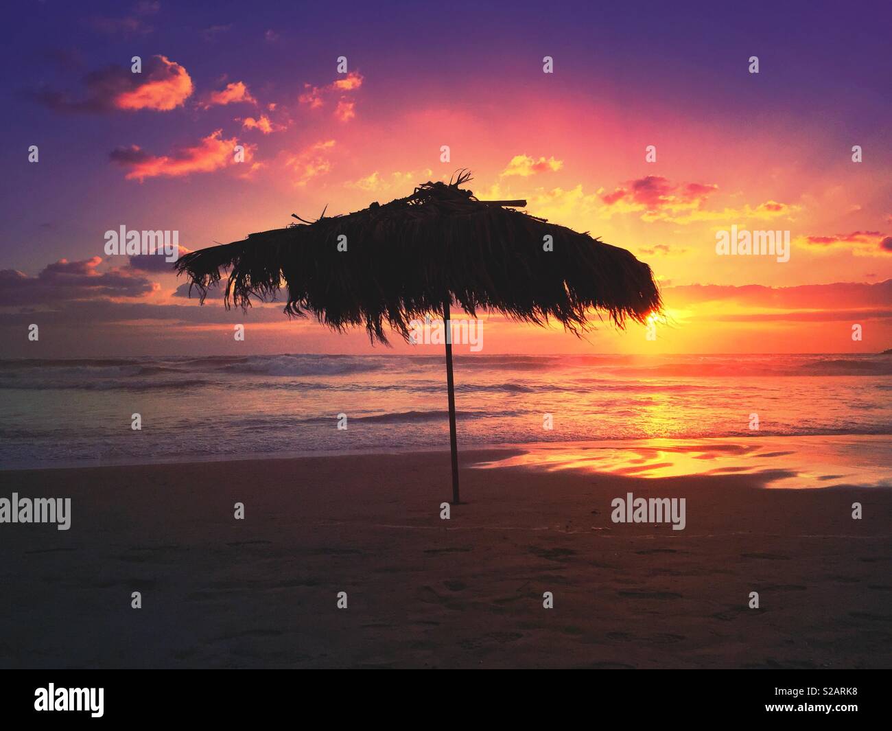 Beach umbrella silhouetted against a beautiful sunset beirut Lebanon - Smartphone Captured Stock Image
