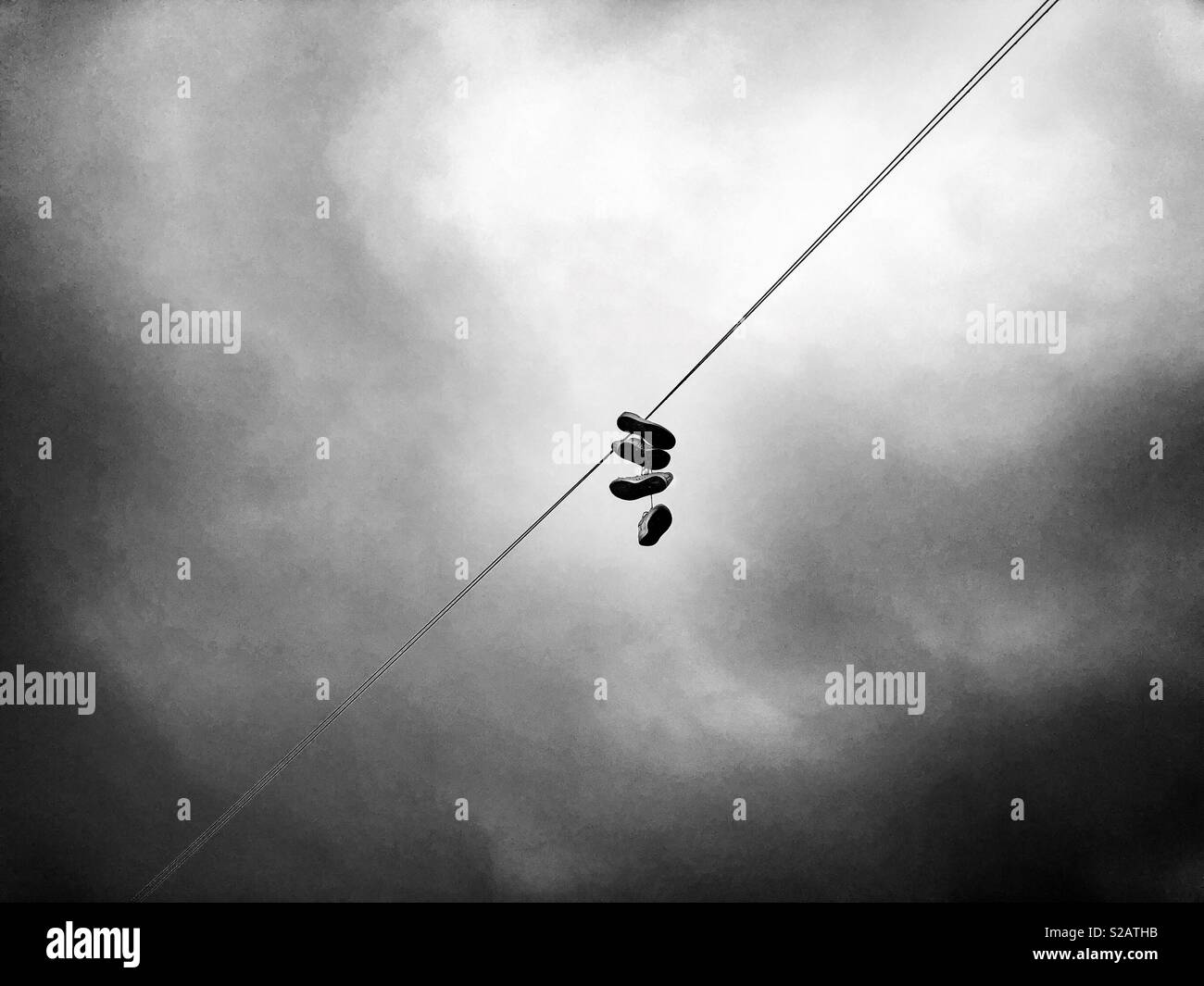 Two pairs of trainers hanging on a telephone line in Cardiff. - Smartphone Captured Stock Image