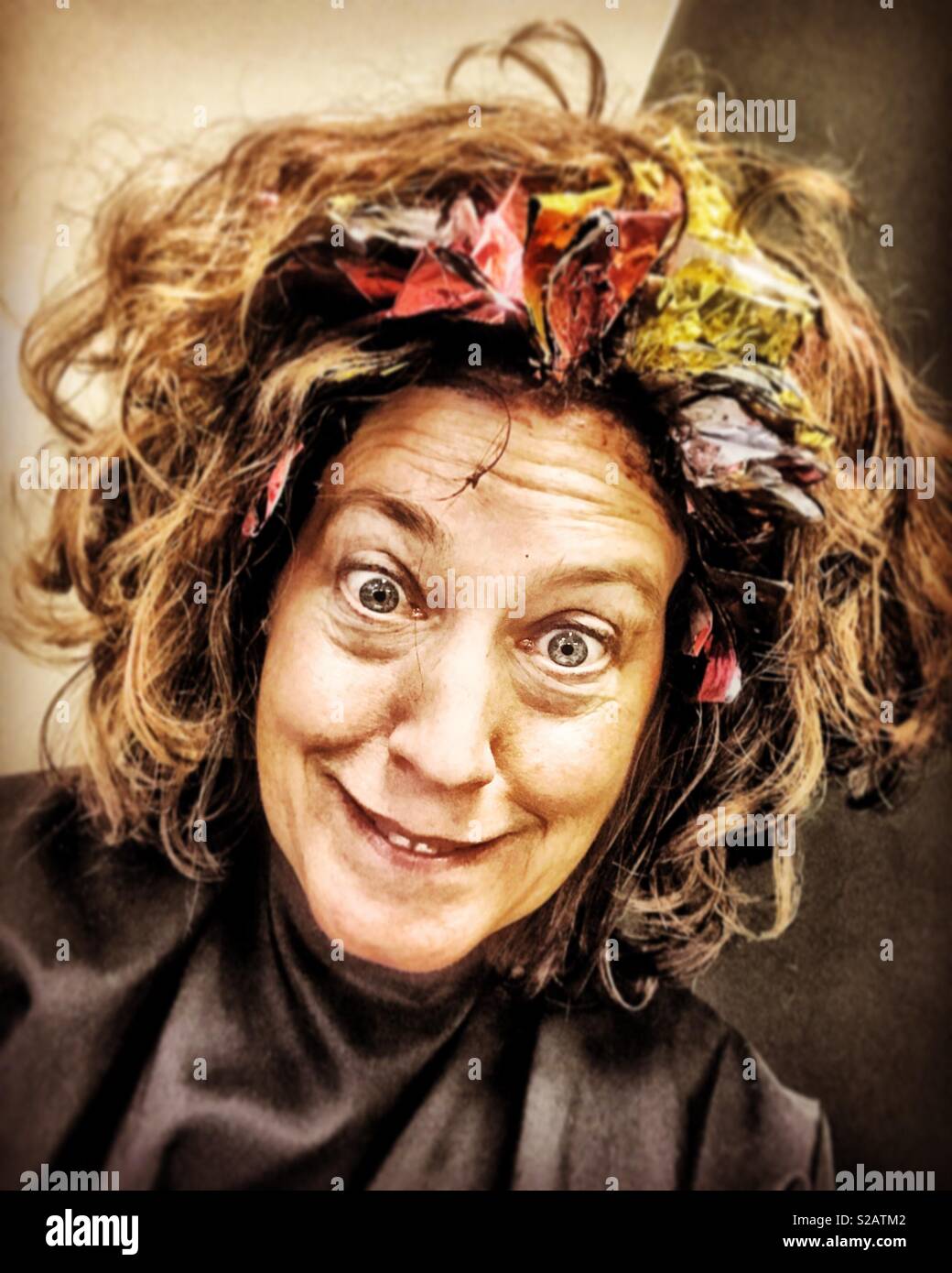 Crazy woman gets hair colored at beauty salon Stock Photo