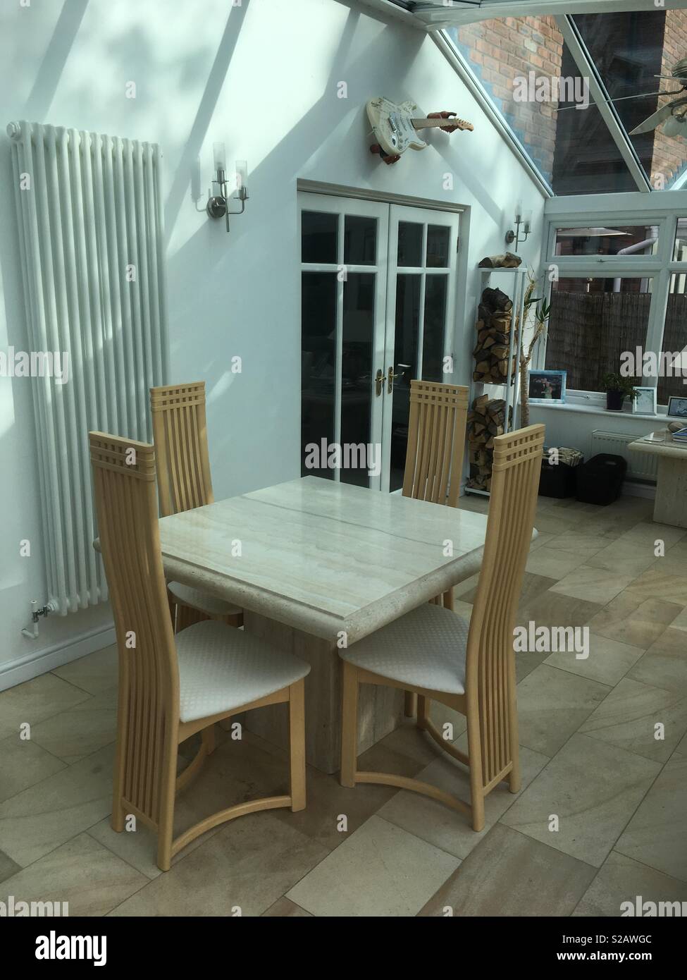 Dining Table Chairs In Conservatory With Guitar Decor On Wall
