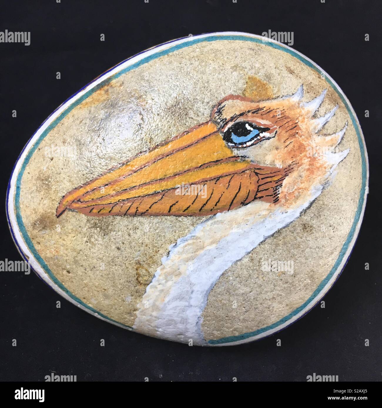 A painted rock depicting a pelican in profile. - Smartphone Captured Stock Image