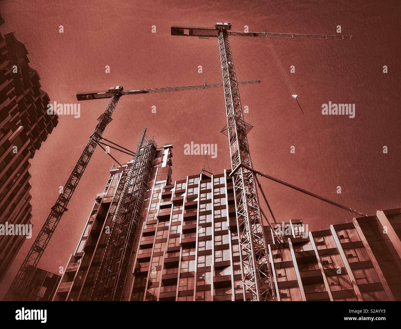 A skyward view from the ground looking up at the construction of a high rise building that will contain housing and retail units. An increasing population means housing is always required. © C.HOSKINS - Smartphone Captured Stock Image