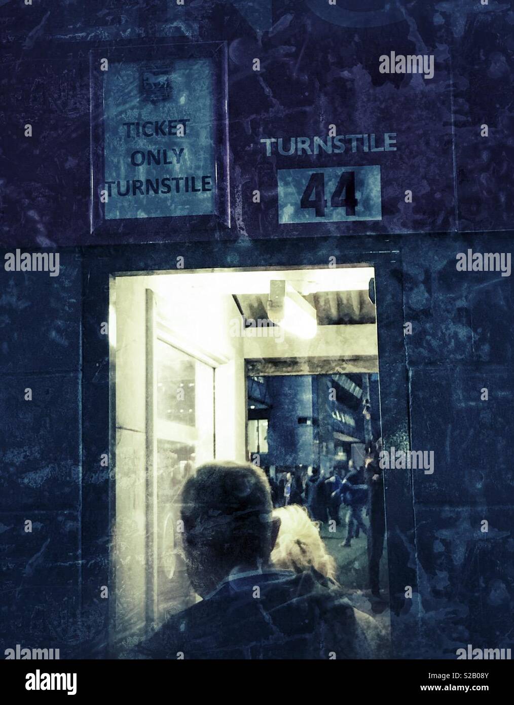 Sport fans passing through a turnstile to watch a match - Smartphone Captured Stock Image