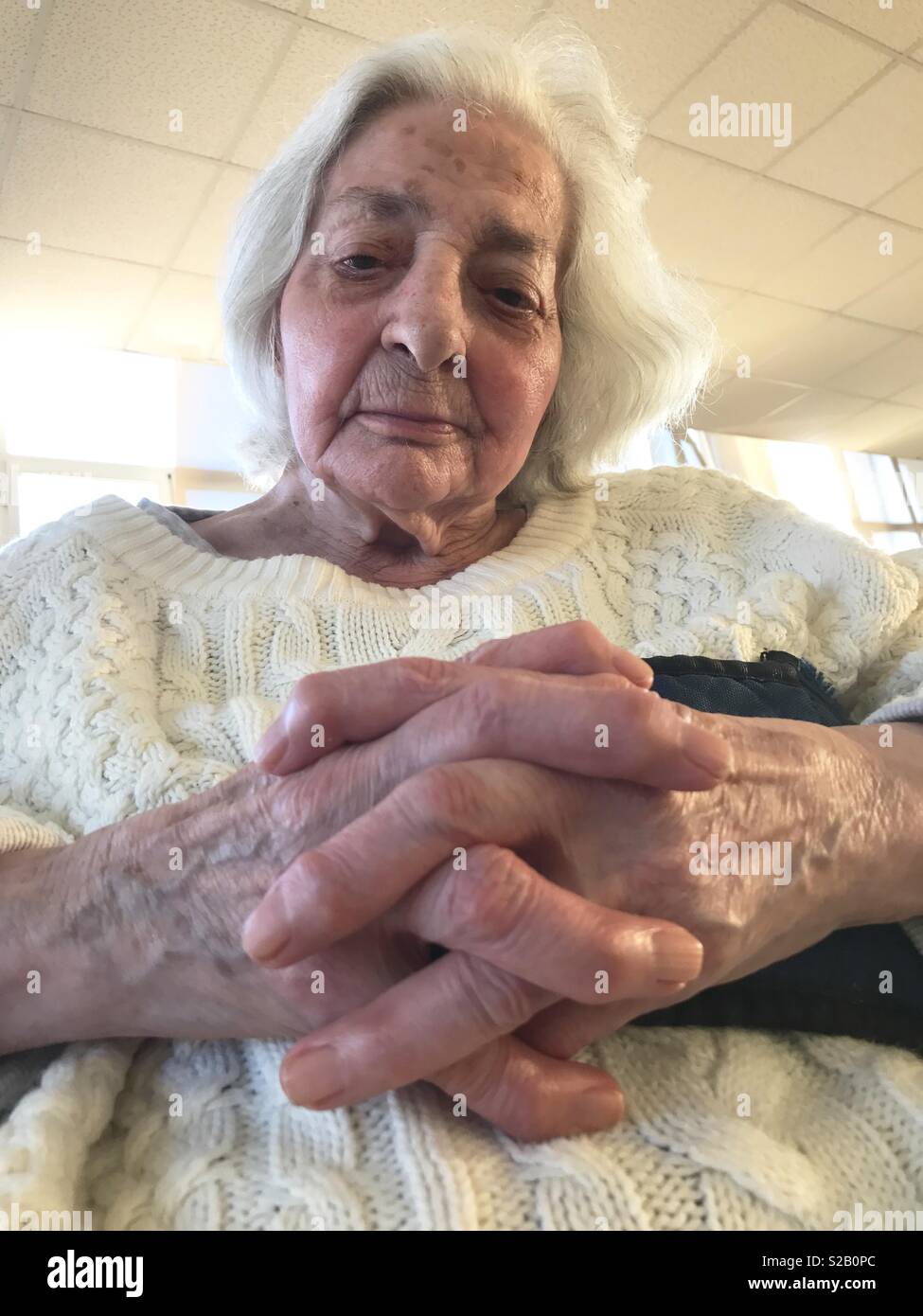 Portrait of old woman crossing hands. - Smartphone Captured Stock Image