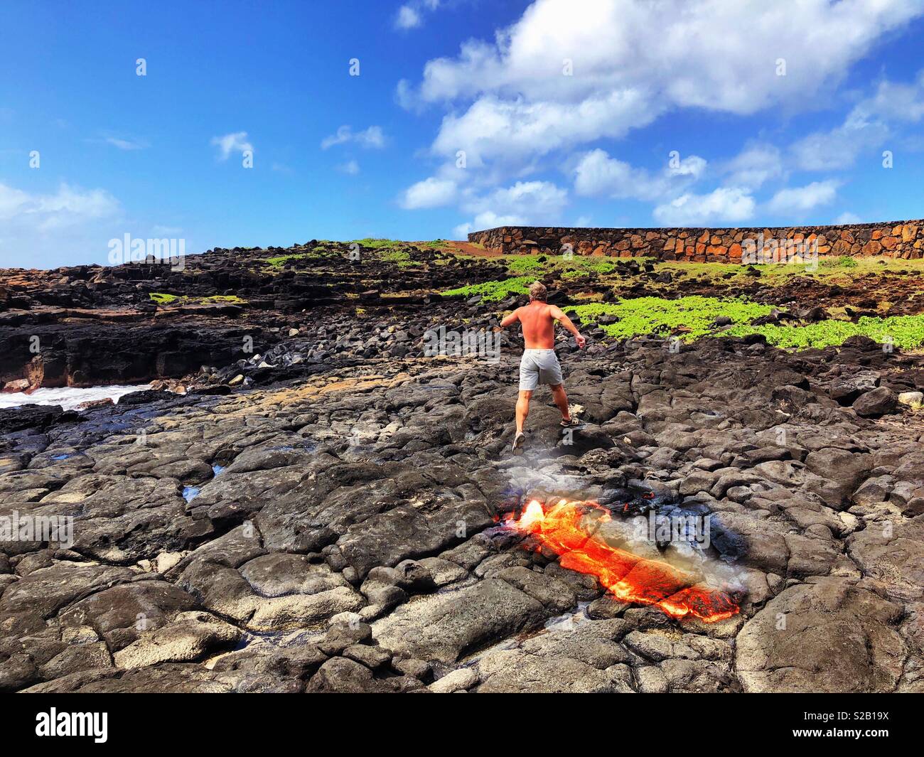 Man running from spewing lava on a Hawaiian coast - Smartphone Captured Stock Image