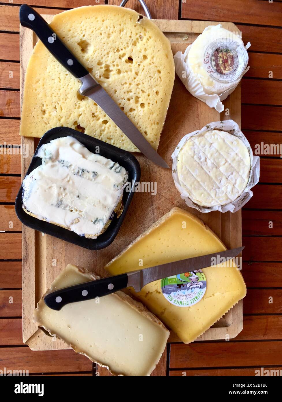 A tray full of cheeses with knives - Smartphone Captured Stock Image