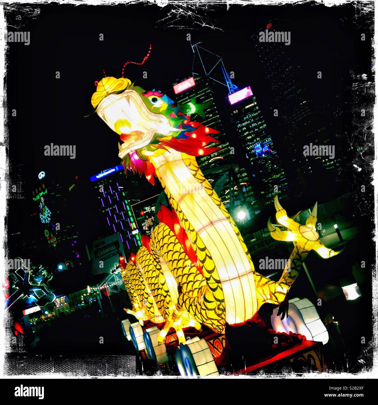 A large illuminated dragon sculpture celebrating Chinese New Year at a funfair at Hong Kong Island's Central district waterfront - Smartphone Captured Stock Image