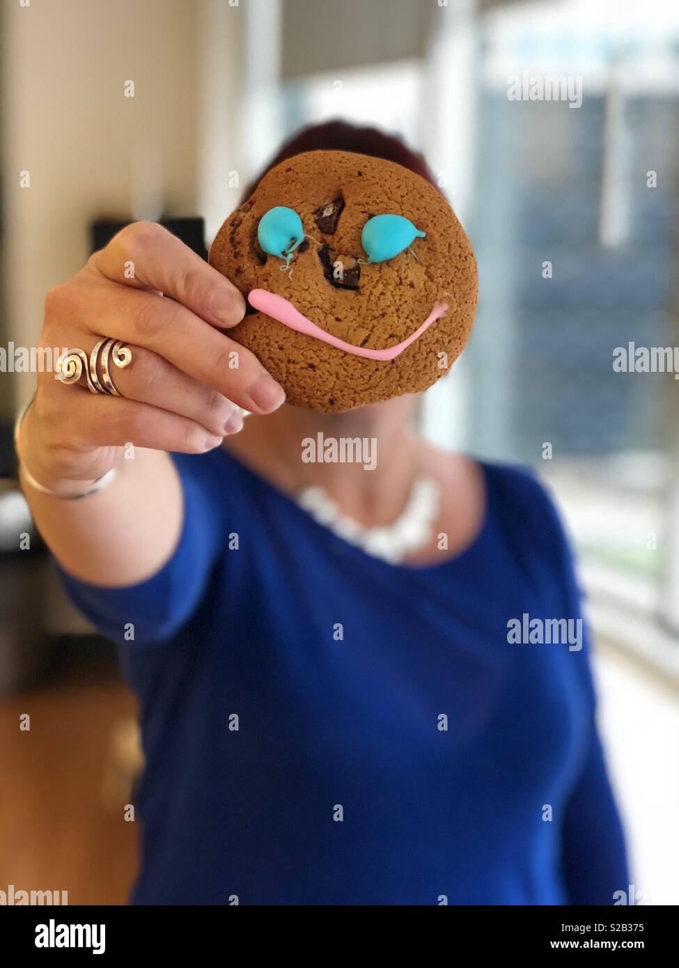 Happy face cookie - woman, cookie, hand with ring, smile, no face Stock Photo