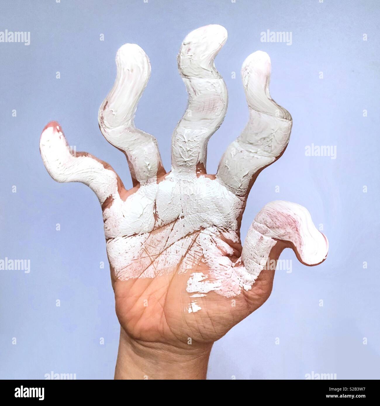 A digital manipulation of a hand covered in white paint with distorted, twisted fingers Stock Photo
