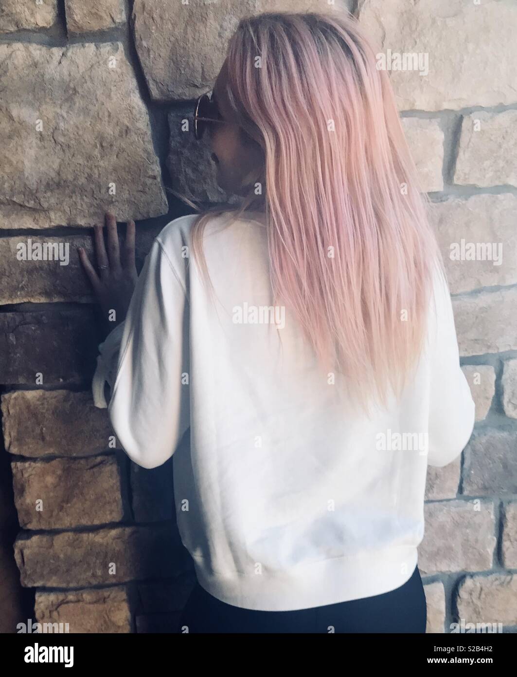 A Blonde Teenage Girl With Pink Hair Modeling By A Cobblestone