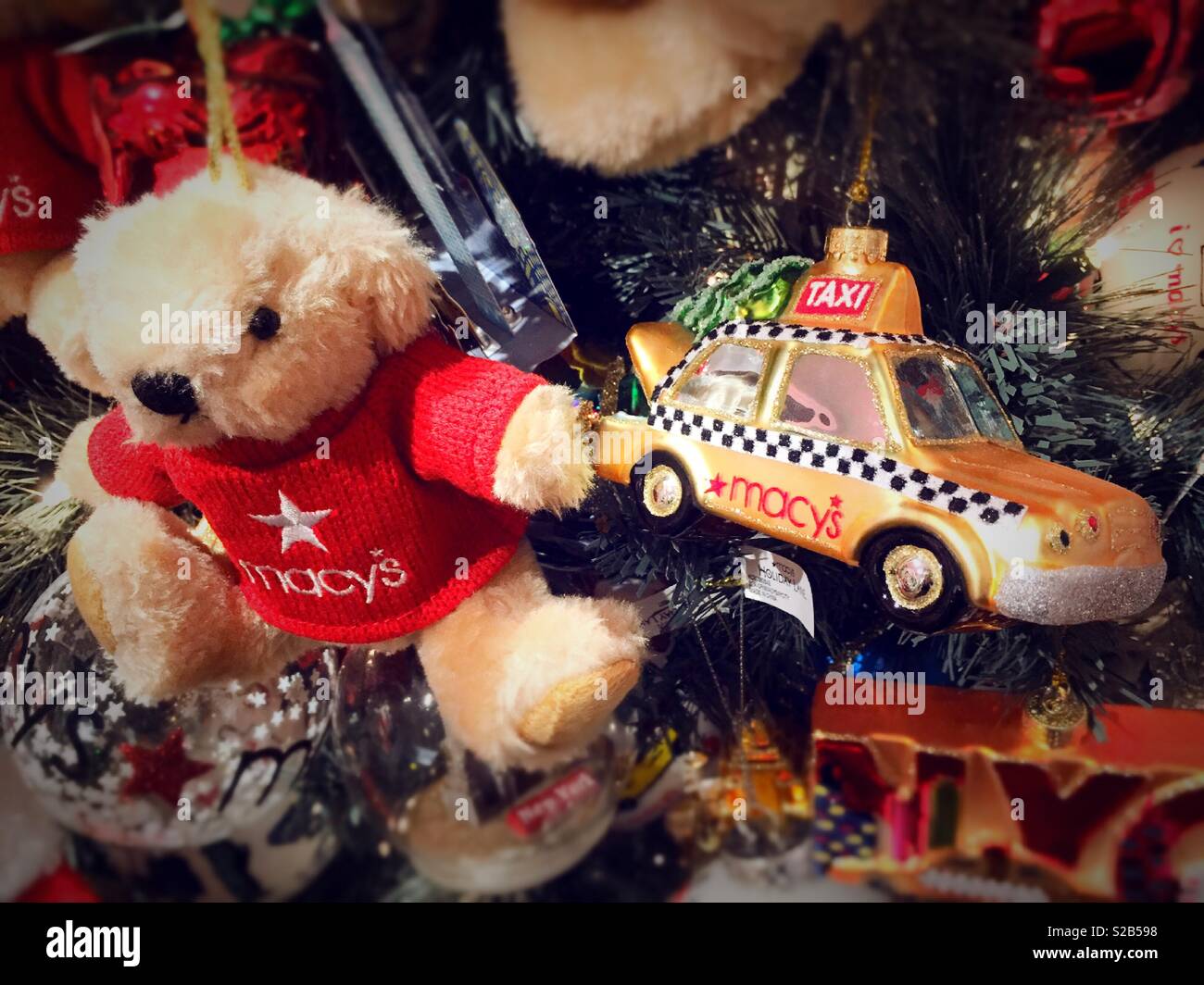 Macy’s holiday Lane featuring teddy bear and NYC taxi cab ornaments hanging from a Christmas tree, NYC, USA Stock Photo