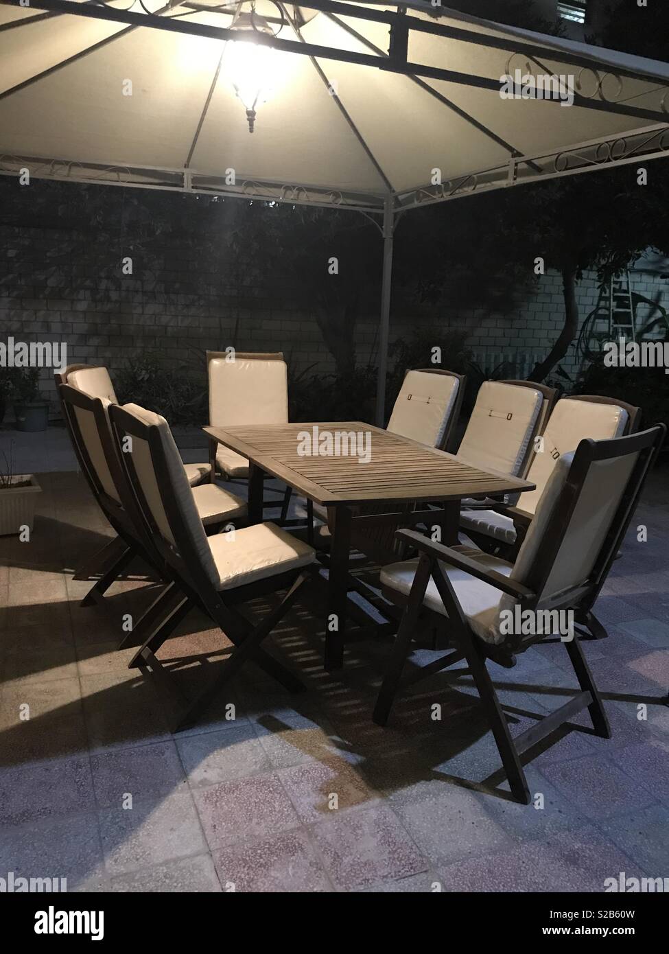 Night gathering: a group of empty chairs with a table waiting for people to sit on - Smartphone Captured Stock Image