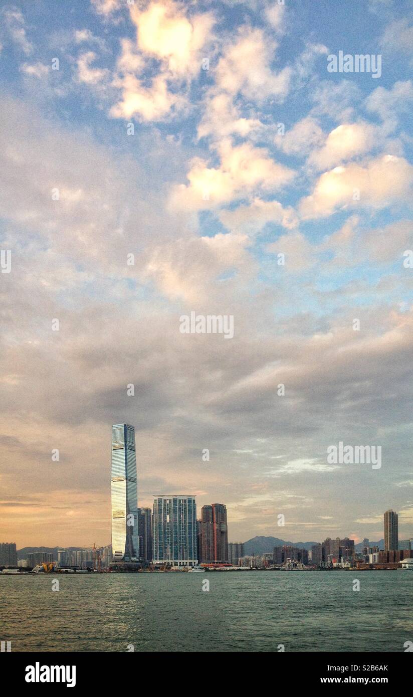 The late afternoon sky reflected in the glass curtain wall of the ICC, Hong Kong's tallest building - Smartphone Captured Stock Image