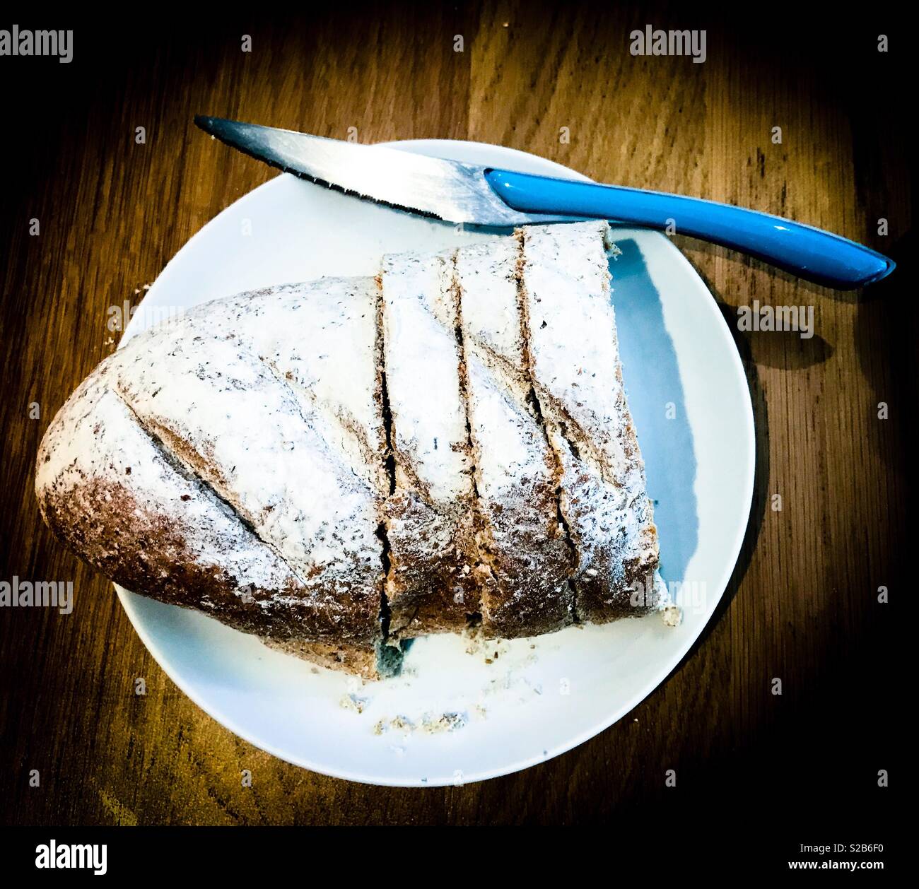 Loaf of wholemeal bread cut into slices with knife - Smartphone Captured Stock Image