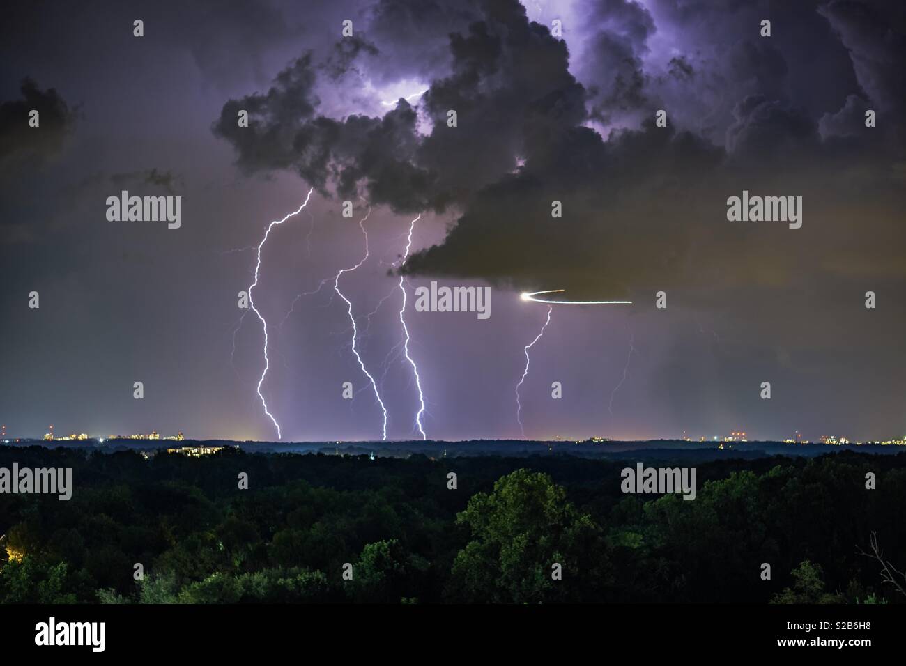 Lightning crashing as a helicopter flees Stock Photo