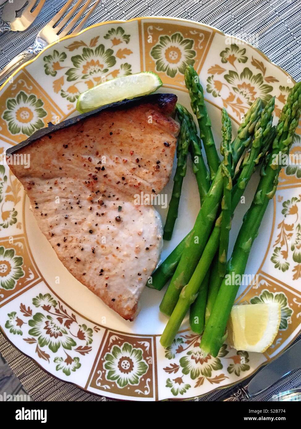 Grilled swordfish steak and asparagus on a beautiful royal crown derby bone china plate, USA - Smartphone Captured Stock Image