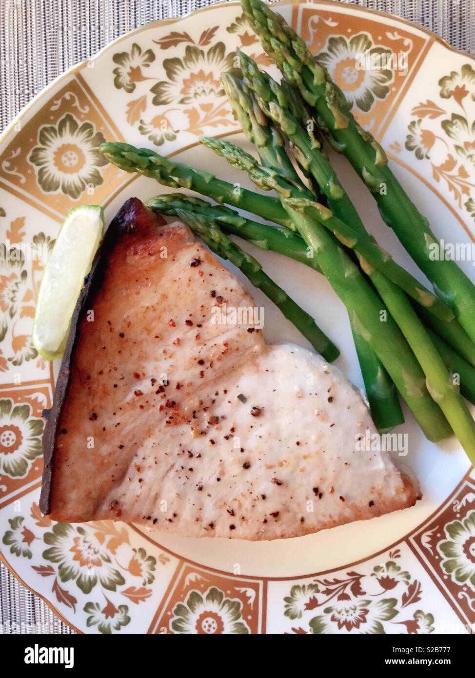 Grilled swordfish steak and asparagus on a beautiful royal crown derby bone china plate, USA - Smartphone Captured Stock Image