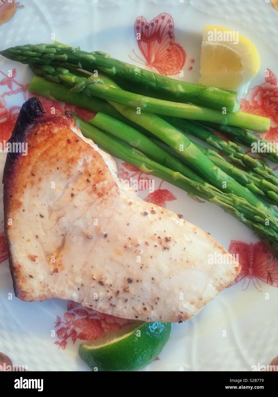 Grilled swordfish steak and asparagus on a beautiful china plate, USA - Smartphone Captured Stock Image