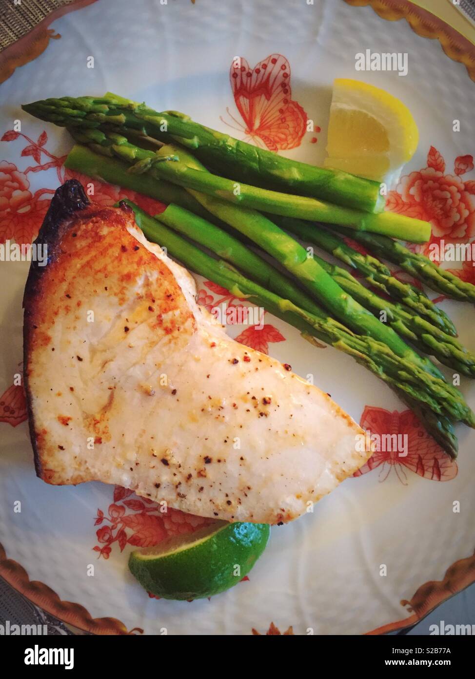Grilled swordfish steak and asparagus on a beautiful china plate, USA - Smartphone Captured Stock Image