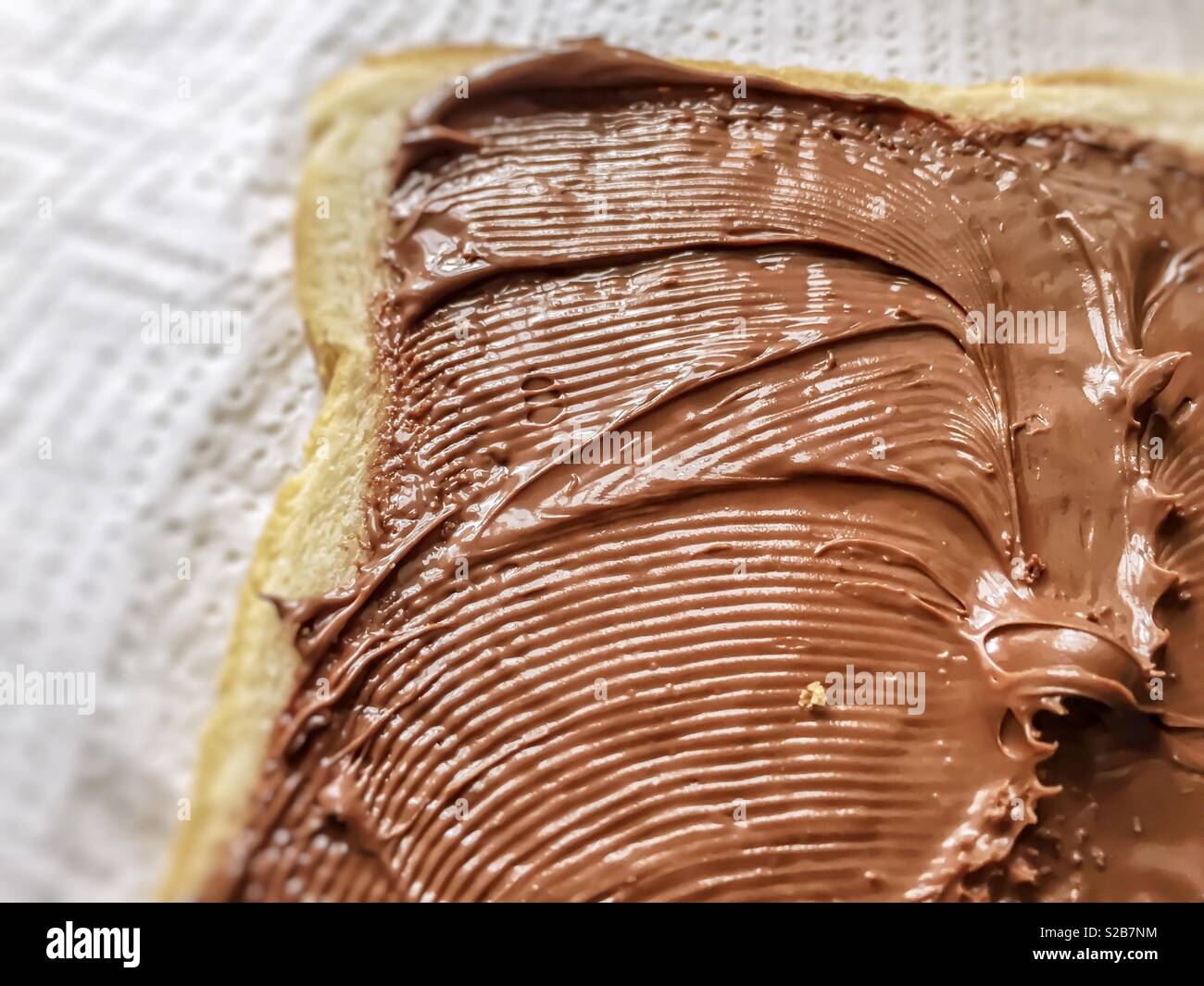 Chocolate cream spread on a slice of bread - Smartphone Captured Stock Image