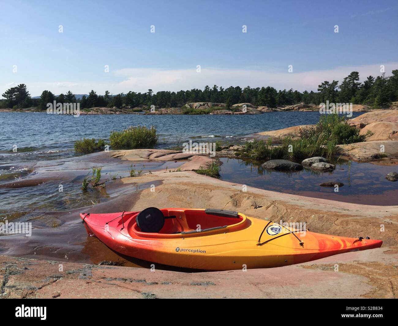 Kayak yellow and orange on an island on Huron Lake, Ontario, Canada. Killarney Provincial Park. Outdoor leisure in a Summer day Stock Photo