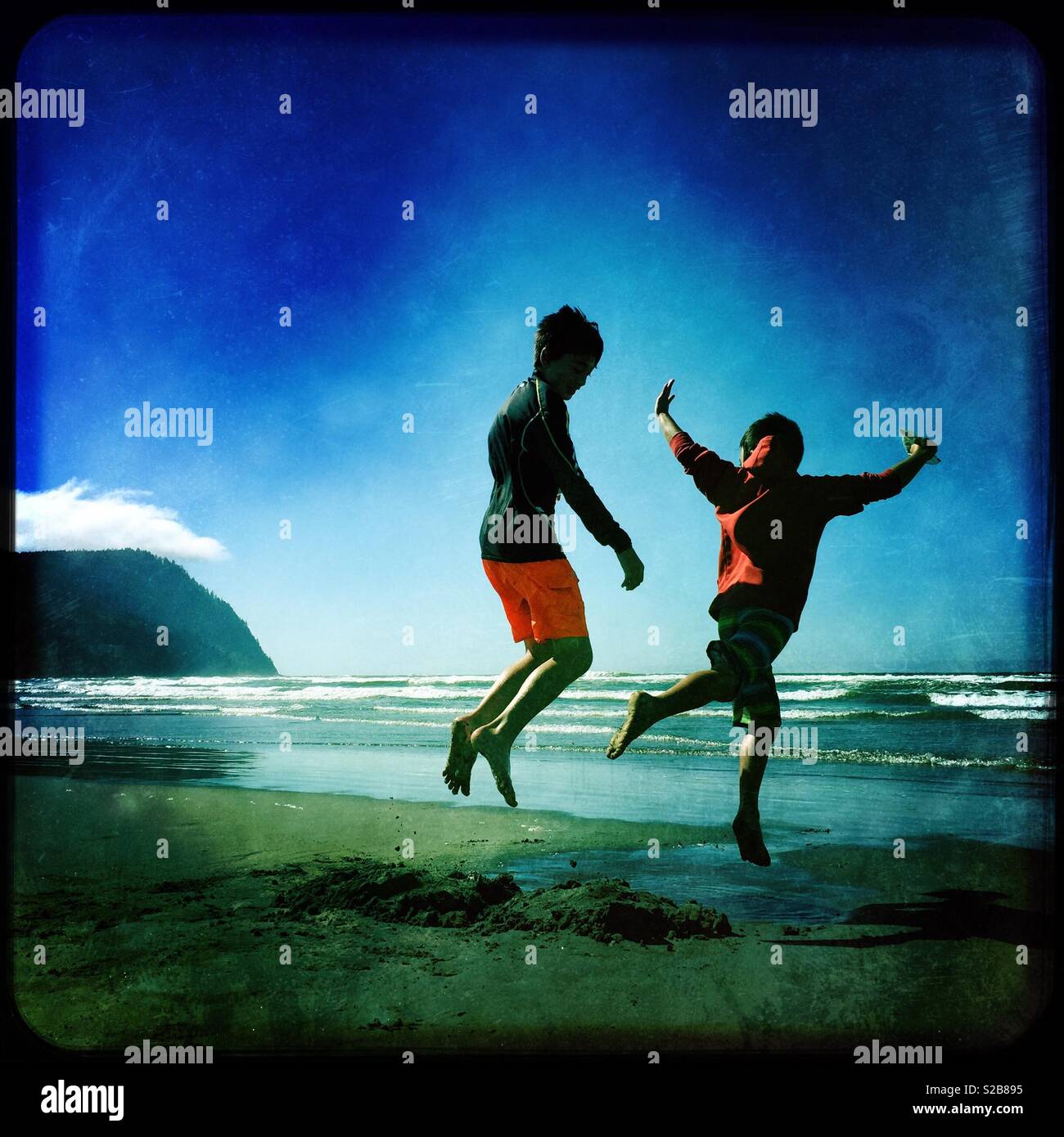 Two brothers playing on beach at Oregon coast Stock Photo