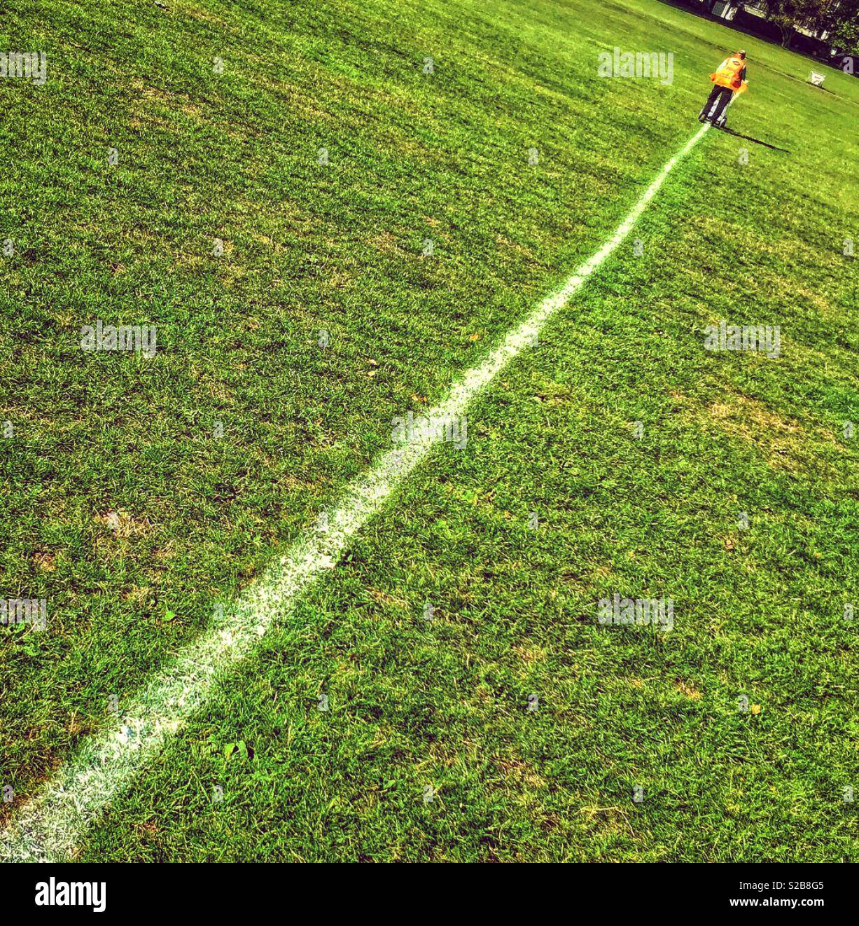 A man painting a white line on grass Stock Photo Alamy