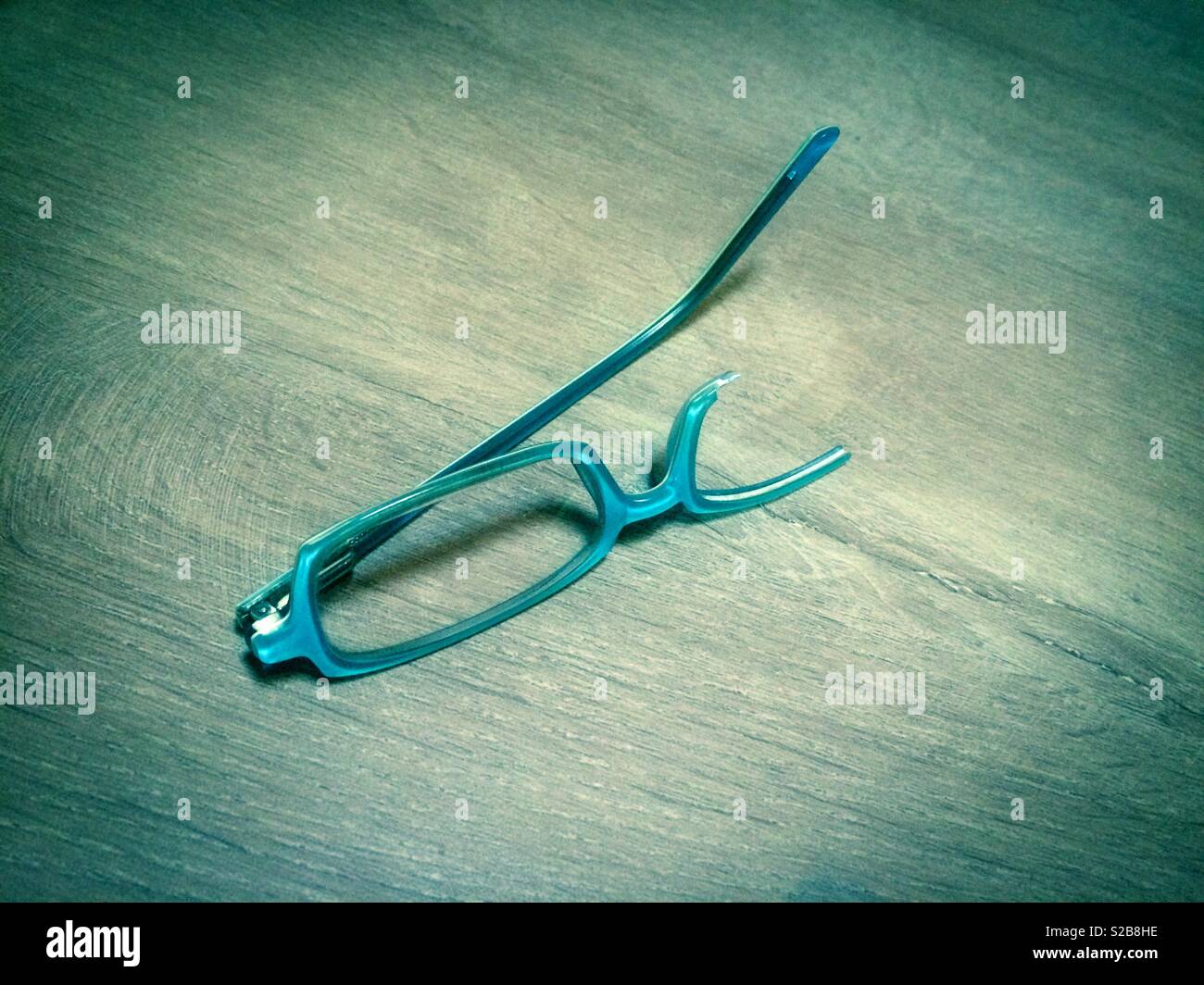 Broken blue eyeglasses Stock Photo