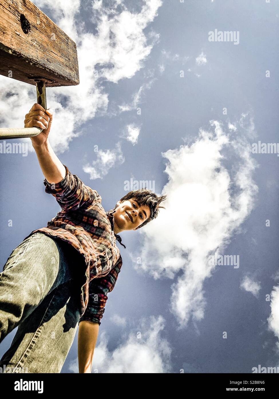 A fourteen year old boy smiling on a jungle gym Stock Photo Alamy