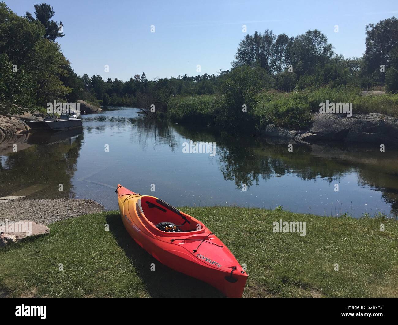 Red and Yellow Kayak on the shore of river. Canadian Summer landscape