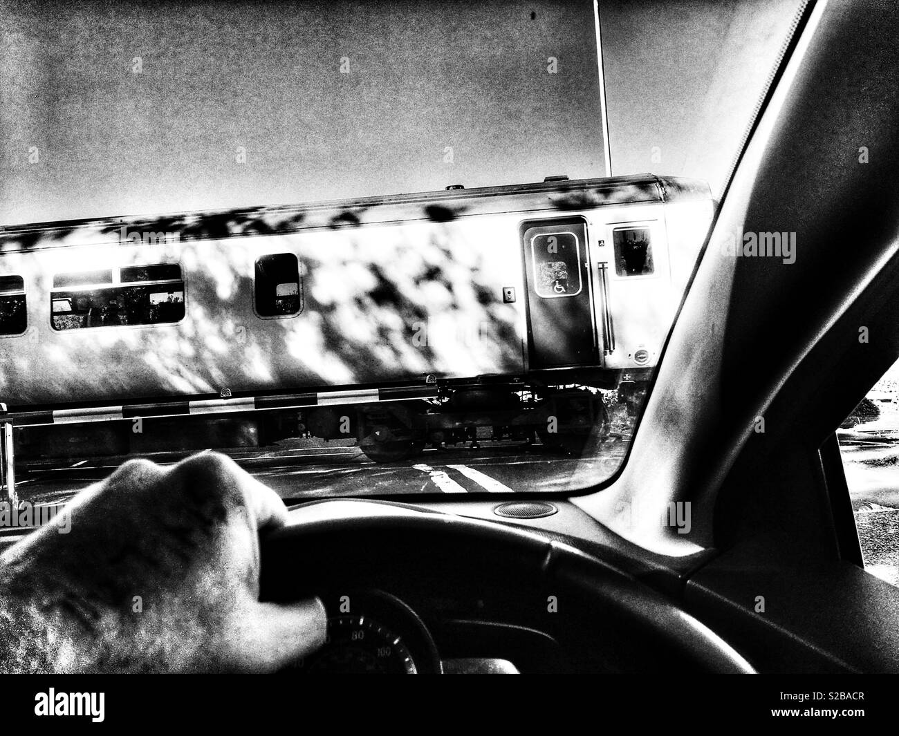 Car driver stopped at railway level crossing, Melton, Suffolk, UK. - Smartphone Captured Stock Image