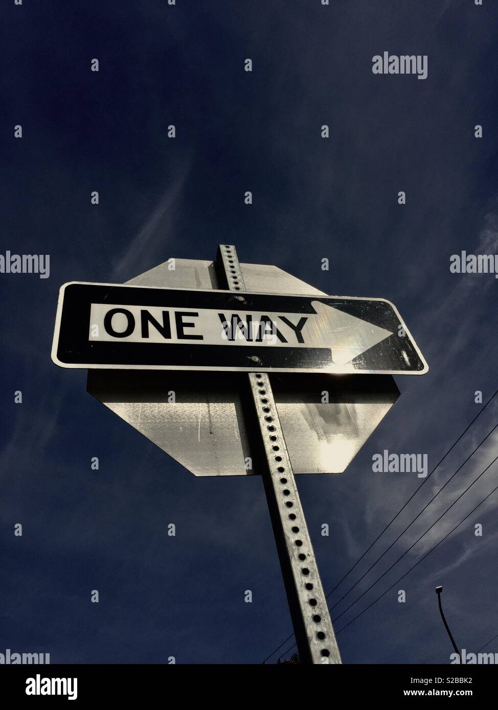 One way sign against blue sky. - Smartphone Captured Stock Image