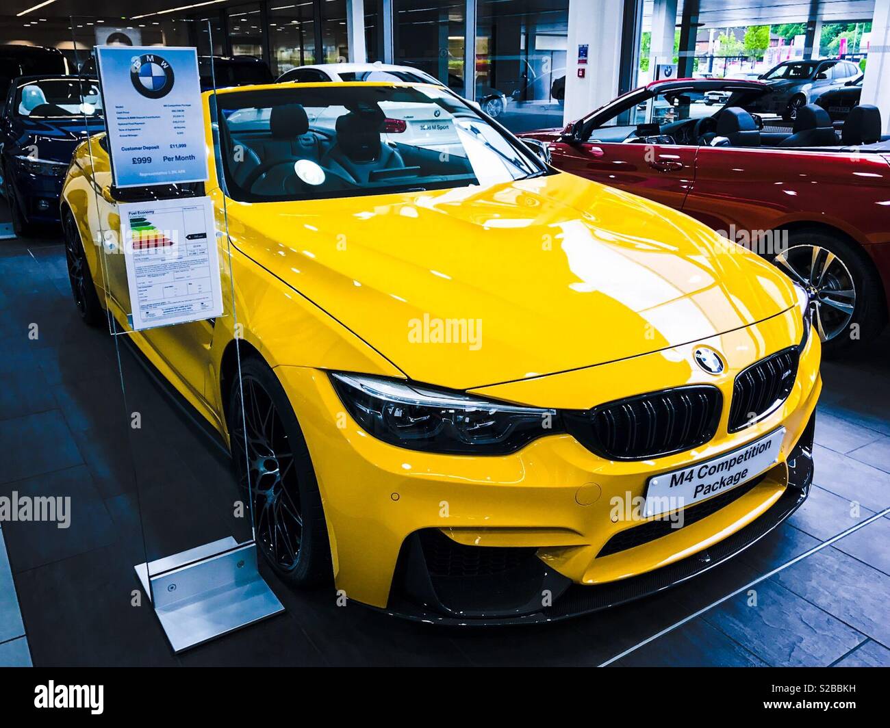 Yellow BMW M4 Competition package for sale in showroom Stock Photo