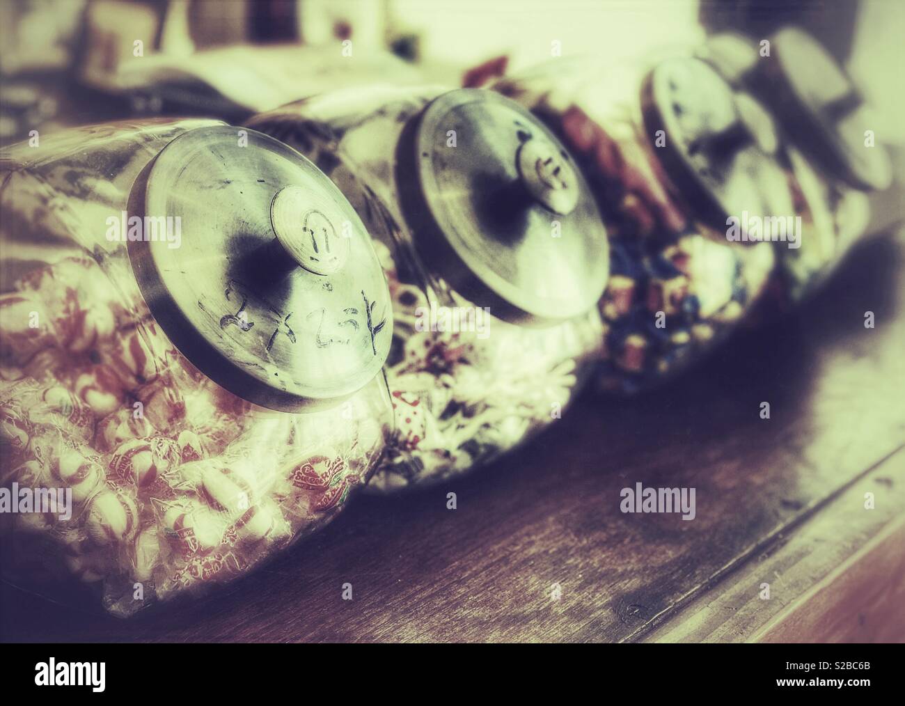 Vintage candy jars lined up on an old general store counter - Smartphone Captured Stock Image