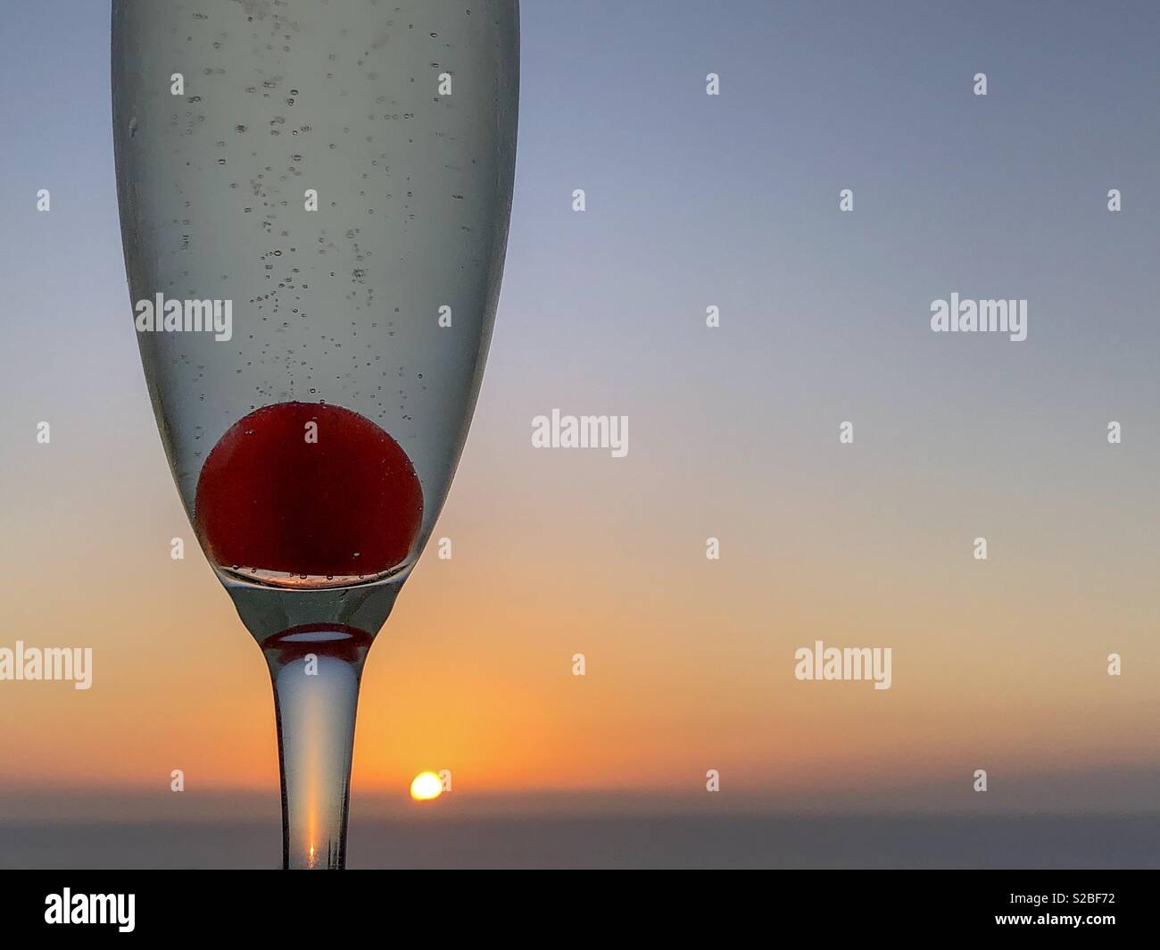 Glass of fizz and bubbles at sunset - Smartphone Captured Stock Image
