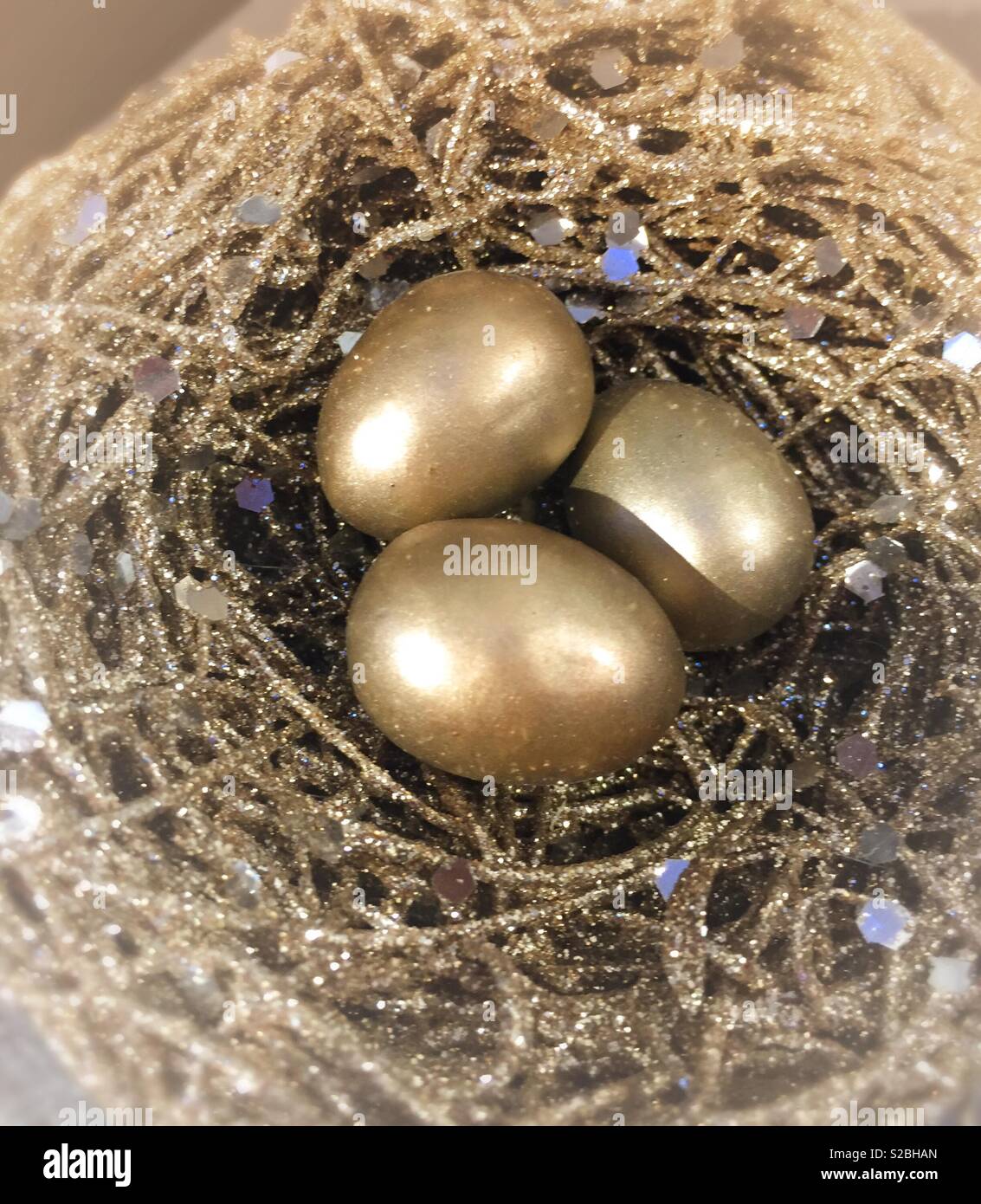 Gold colored eggs in a gilded nest, USA Stock Photo