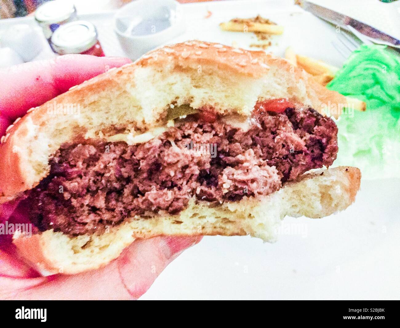 Half eaten juicy cheeseburger Stock Photo
