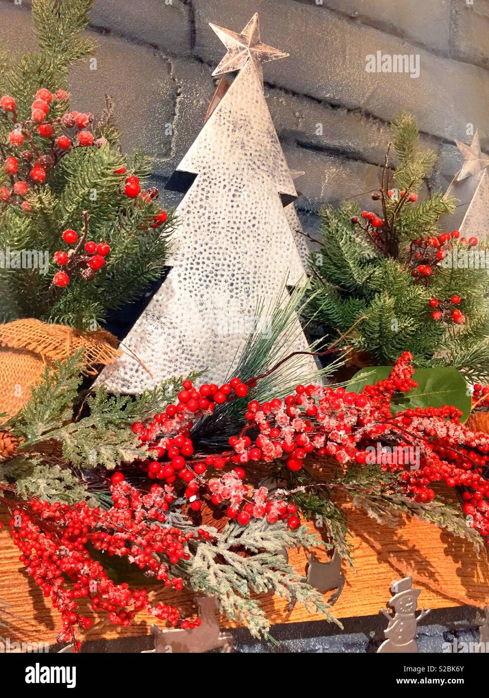 Holiday decorative display featuring Christmas tree and red berries, USA - Smartphone Captured Stock Image
