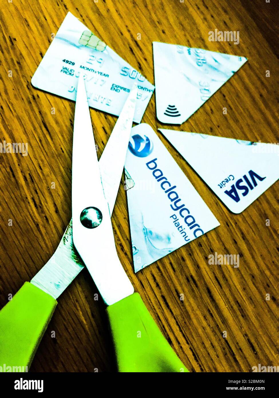 Credit card cut into pieces with pair of scissors - Smartphone Captured Stock Image
