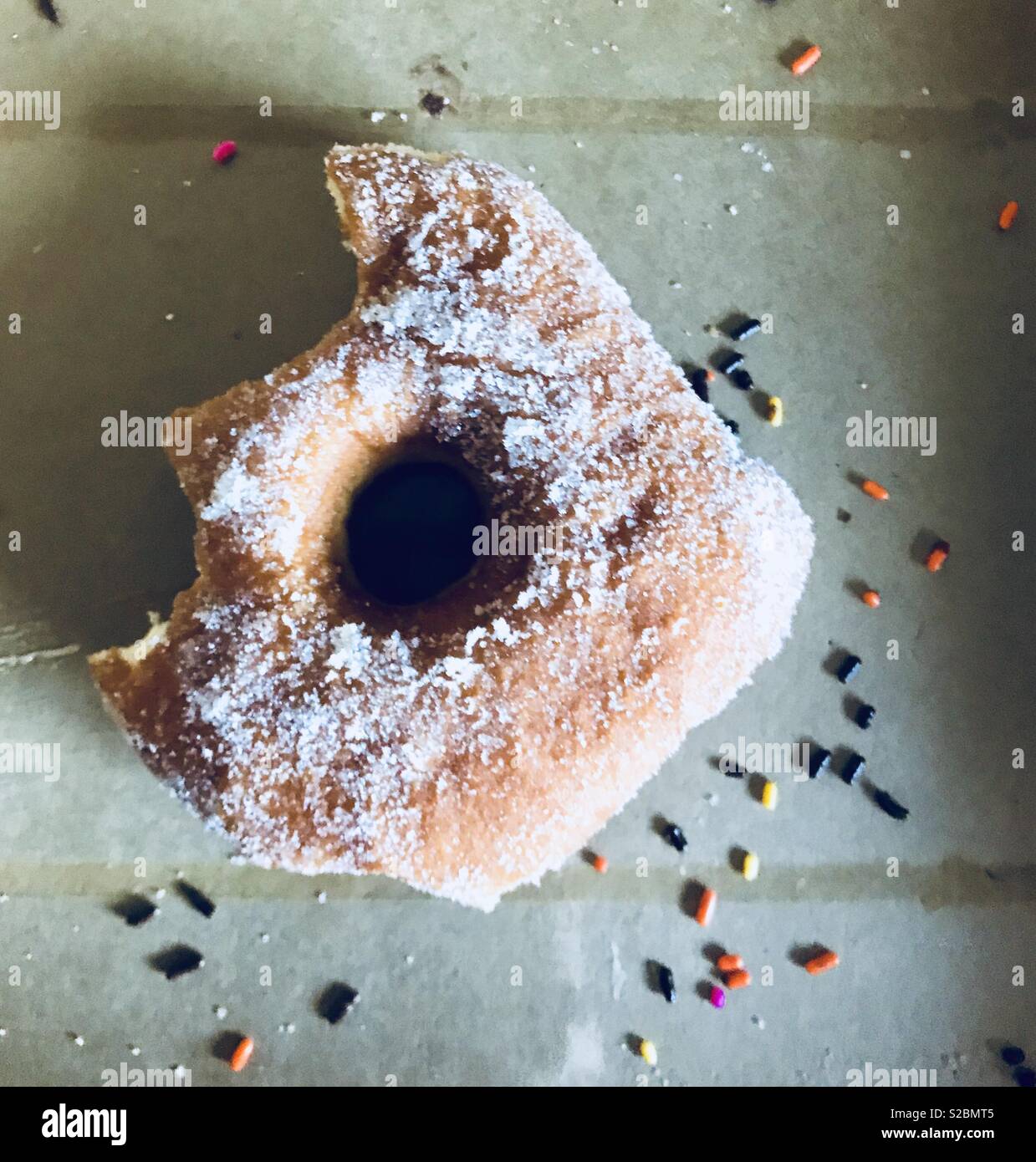 Partially eaten sugar sprinkle doughnut Stock Photo